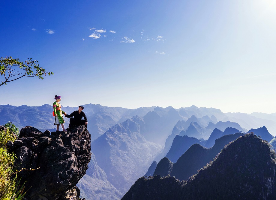 Stunning Ma Pi Leng Pass landscape with motorbikes on the cliffside road, illustrating essential Ha Giang loop tips for adventure riders