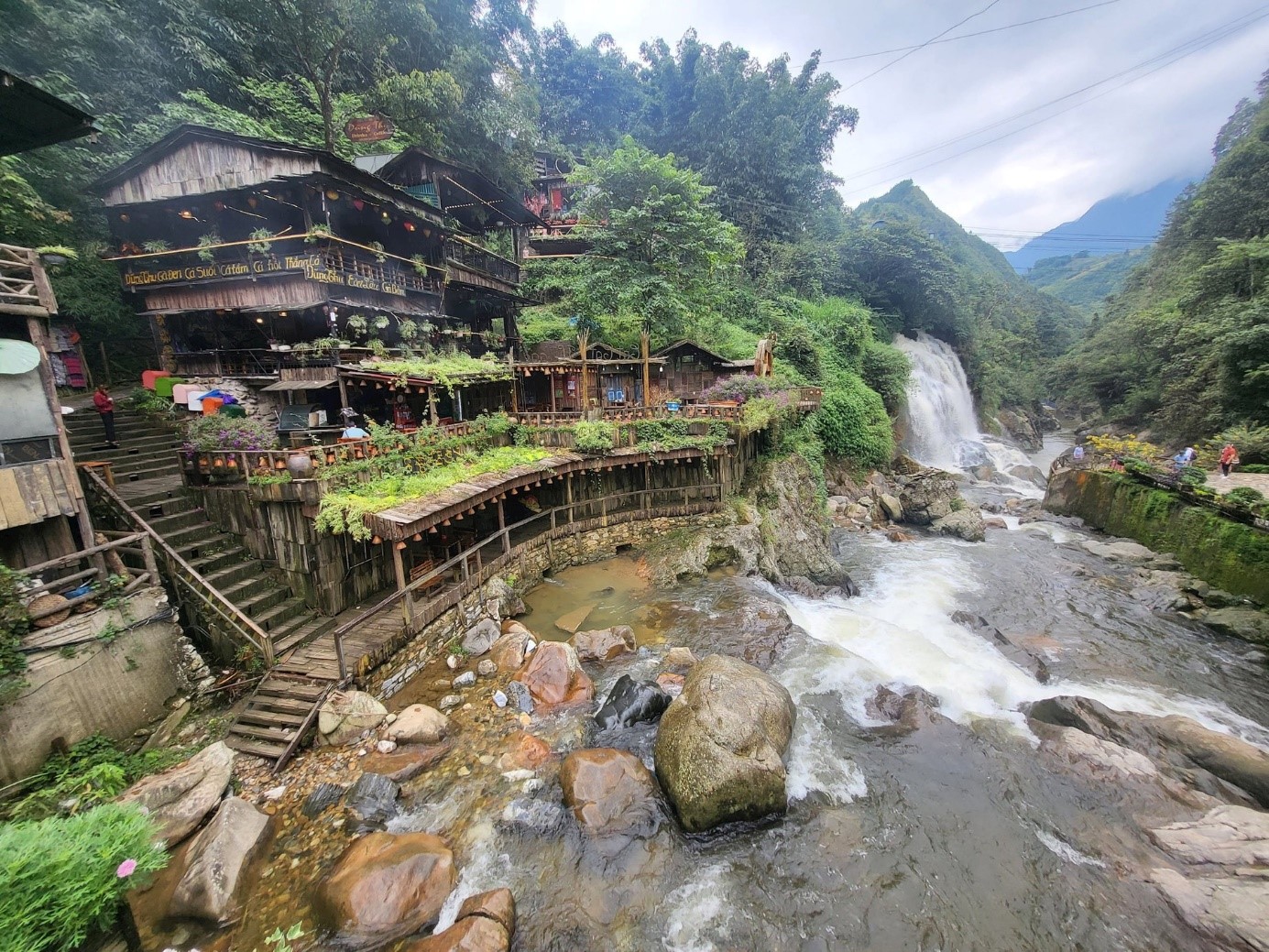 Wooden houses and mountain backdrop in Cat Cat Village Sapa