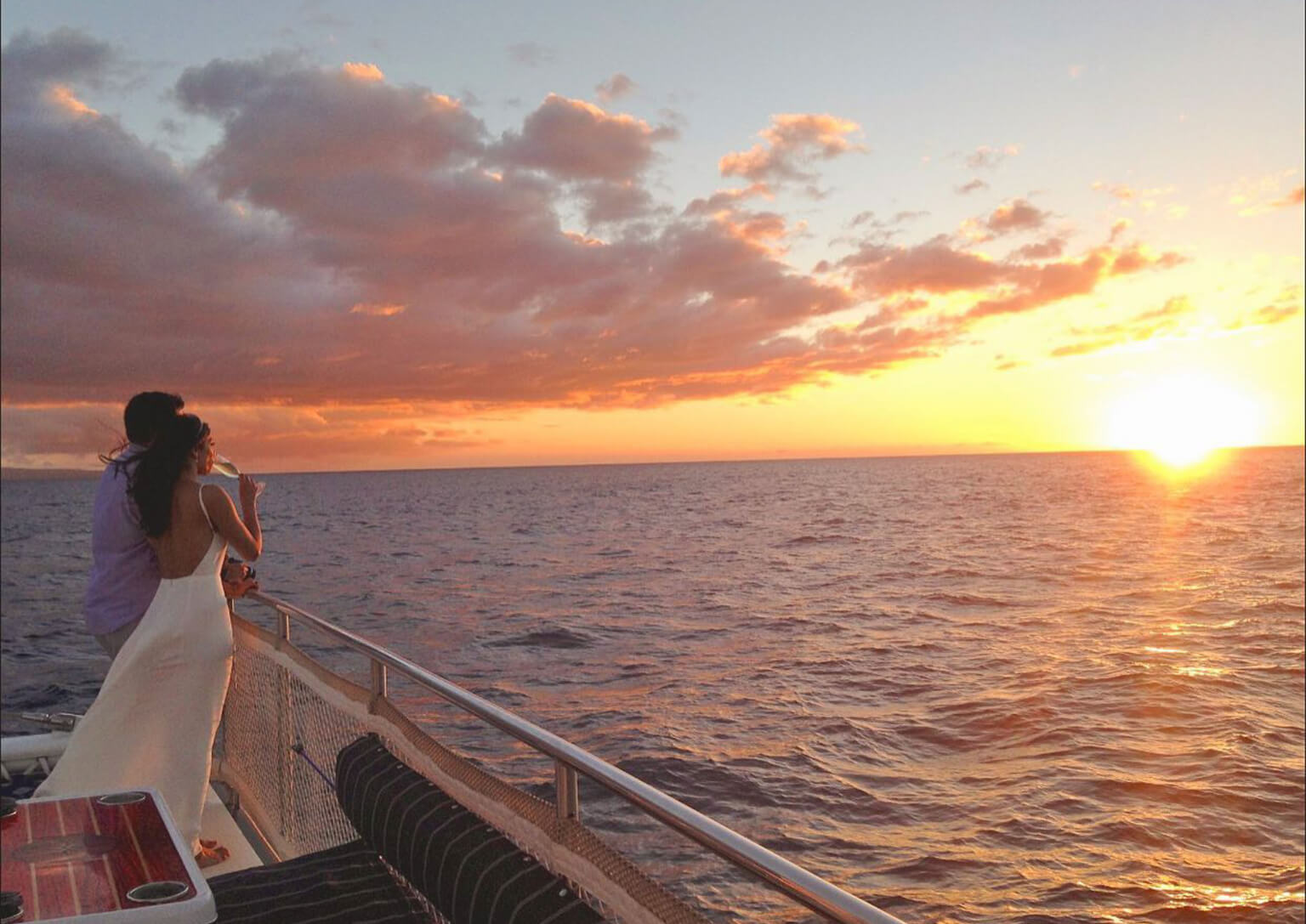 Couple watching the sunset together from a luxury cruise deck