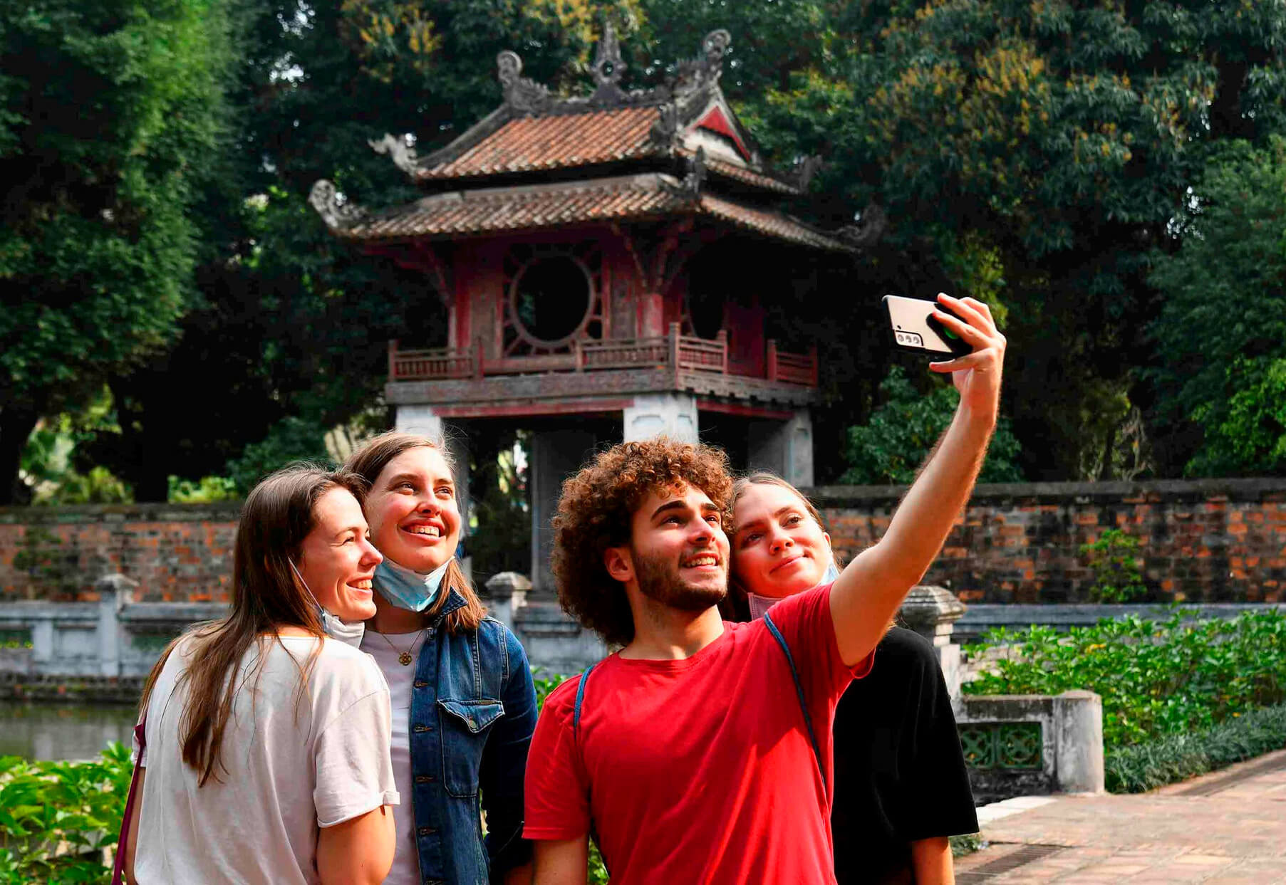 Foreign visitors wearing modest clothing while visiting a traditional Vietnamese temple