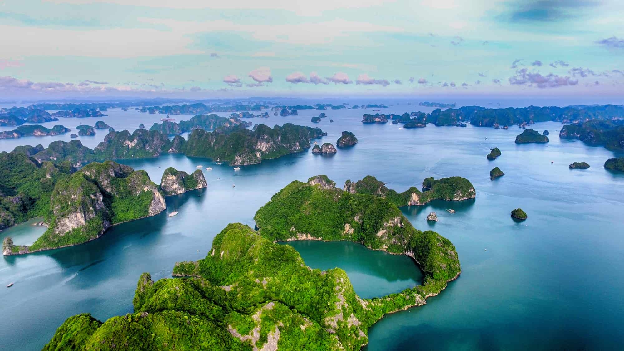 Limestone islands rising from calm waters in Halong Bay