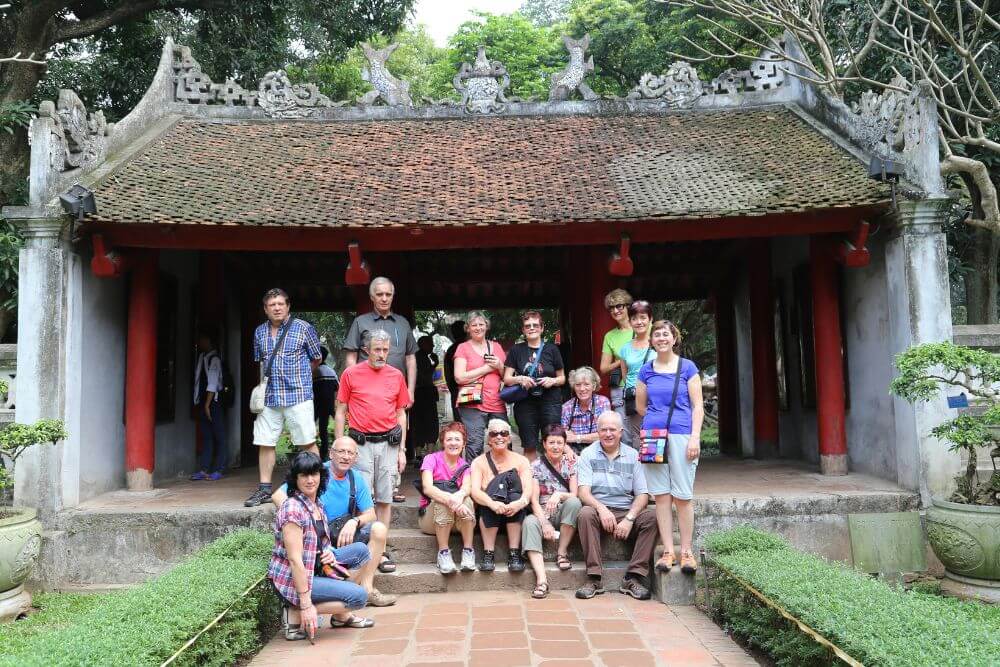 Tourists visiting temple courtyards in Vietnam during hot weather