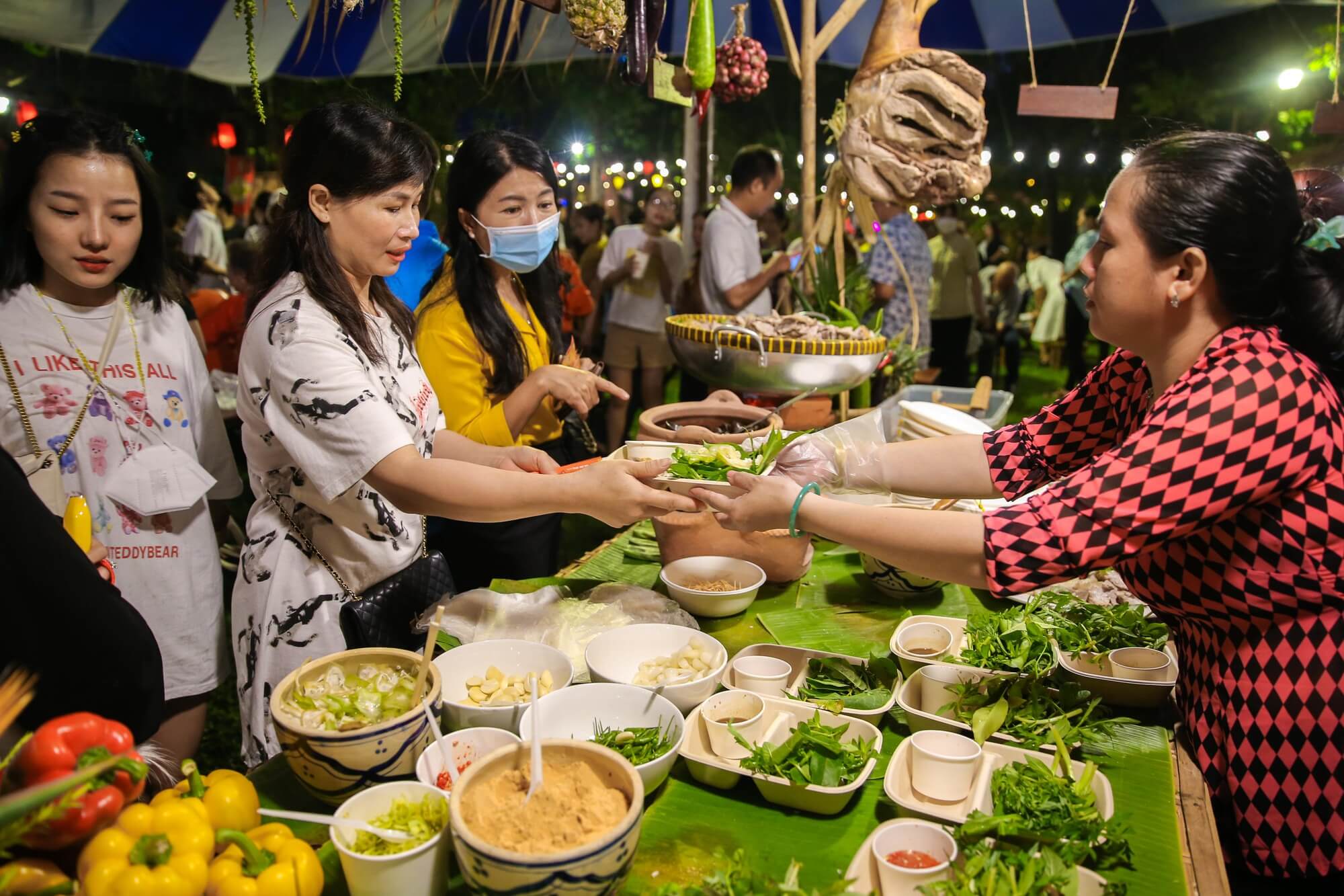 Travelers enjoying Vietnamese street food with locals
