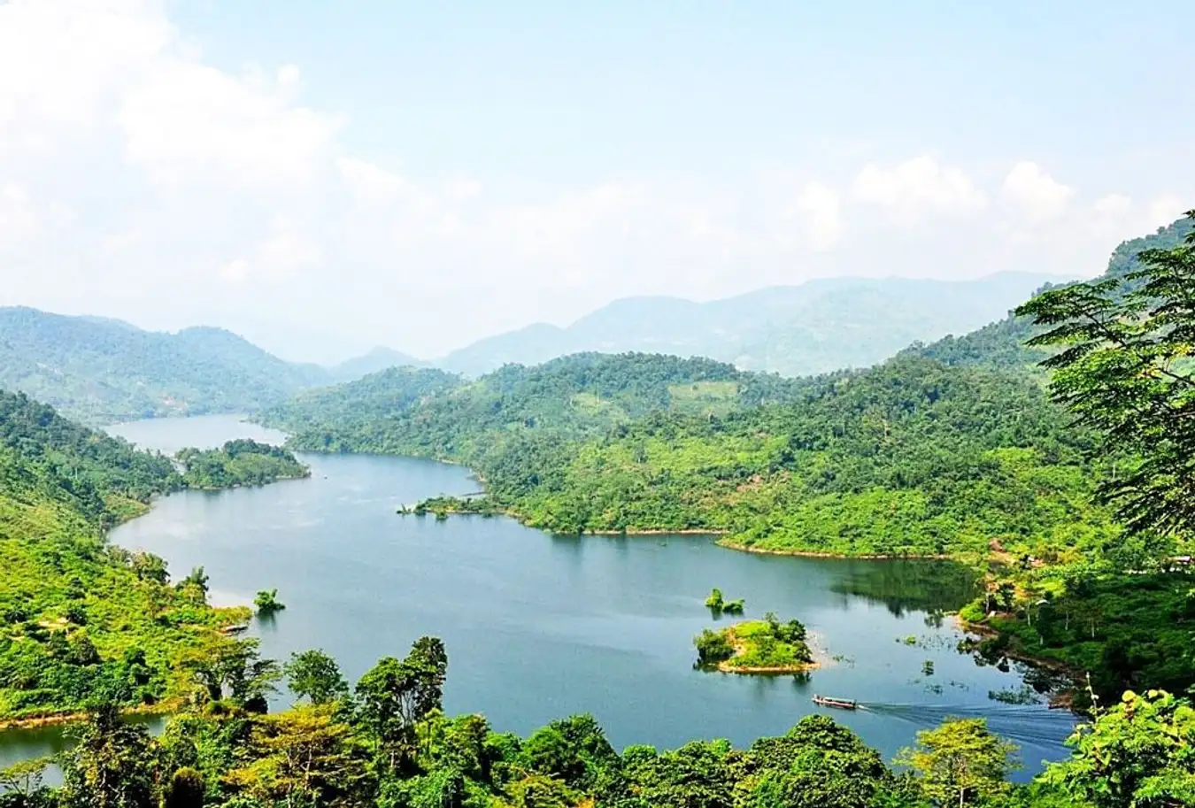 Calm freshwater lake surrounded by limestone mountains in Ba Be National Park