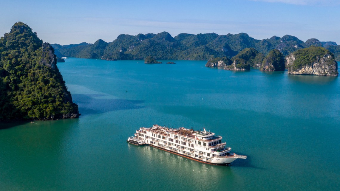 Traditional cruise boat sailing through limestone karsts in Ha Long Bay