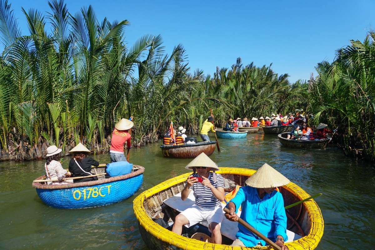 Tourists riding traditional basket boats through the coconut forest in Cam Thanh Village