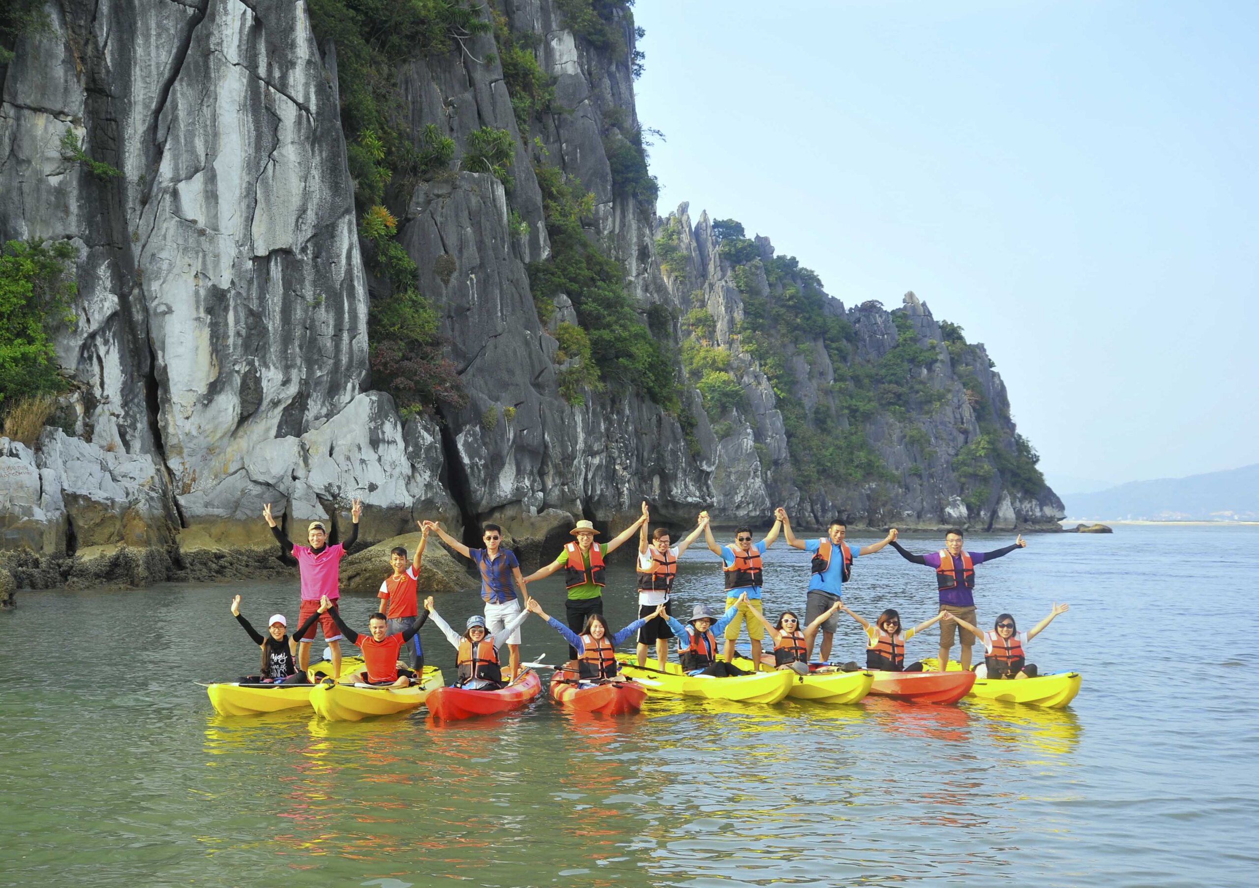 Travelers kayaking and enjoying beach activities in a tropical bay landscape