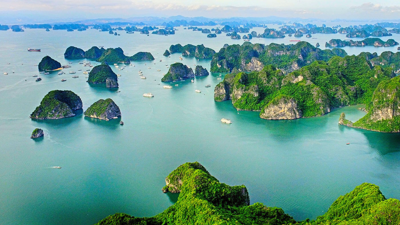 Aerial view of limestone karsts rising from emerald waters in Halong Bay