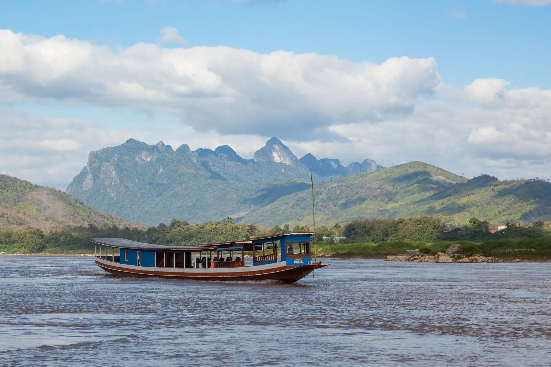 Boat journey along the Mekong River with rural scenery