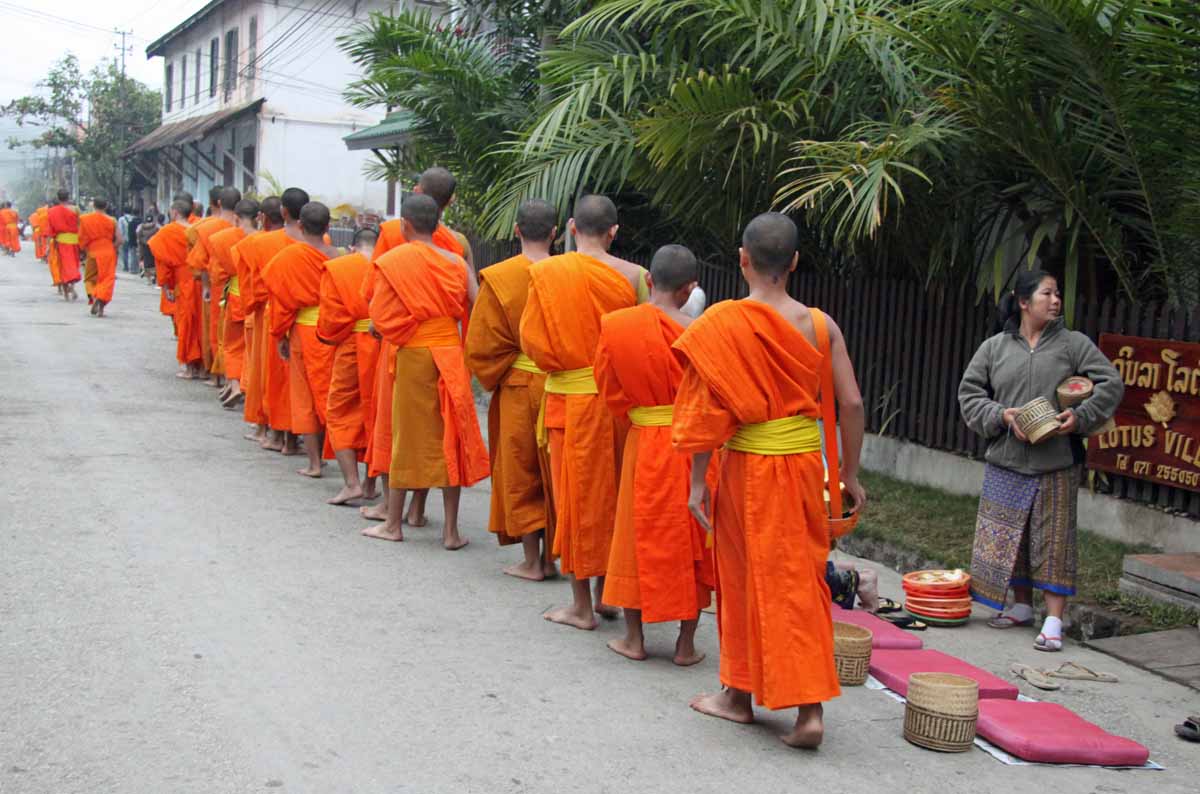 Buddhist monks walking for alms in a quiet Lao town
