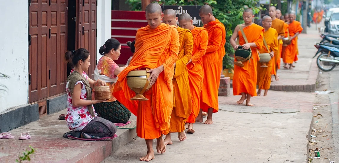 Monks collecting alms during early morning ceremony in Luang Prabang
