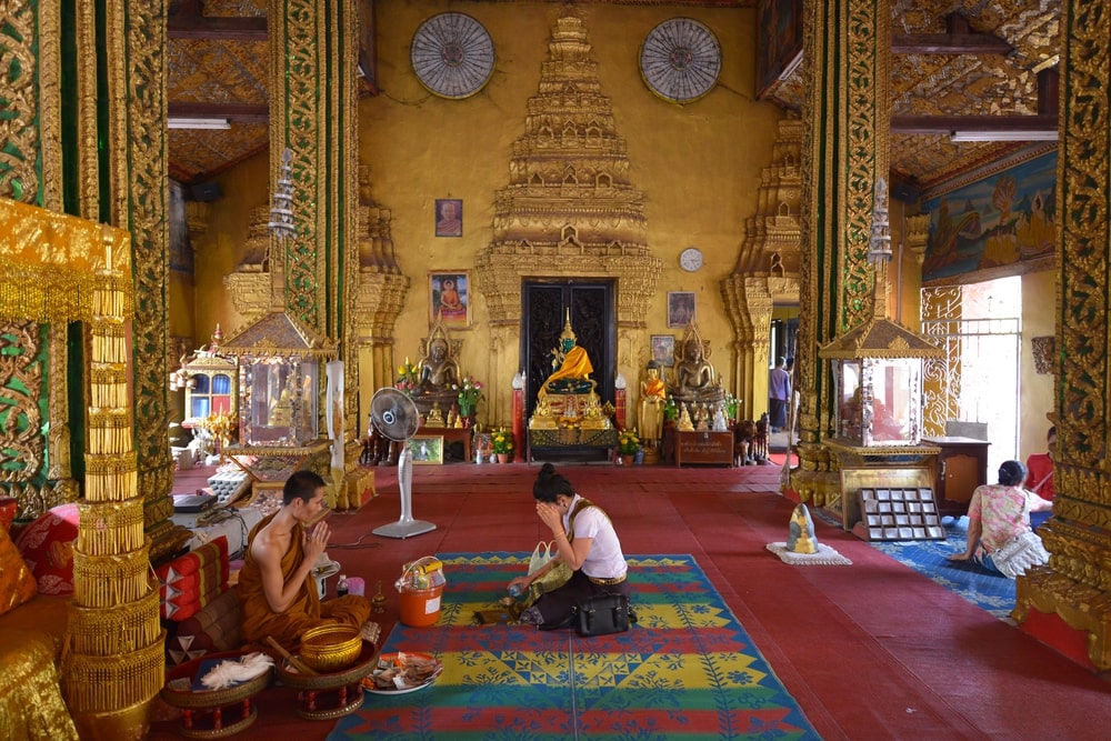 Visitors dressed respectfully inside a Lao temple