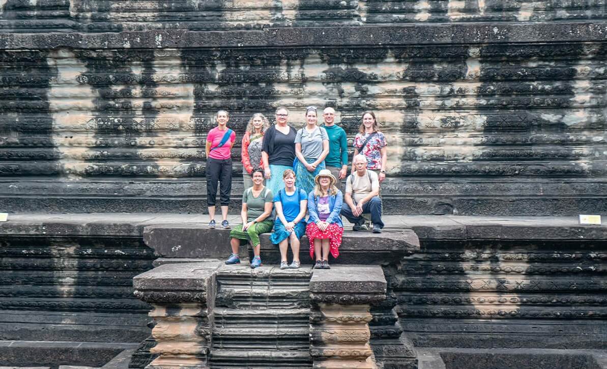 Visitors exploring ancient temples in Cambodia during a hot sunny day